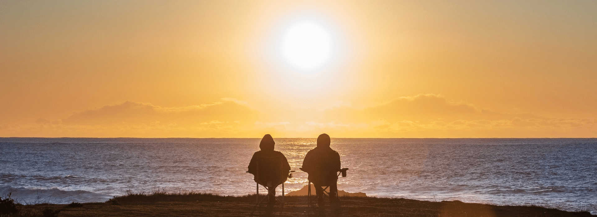 couple looking out over water at sunset